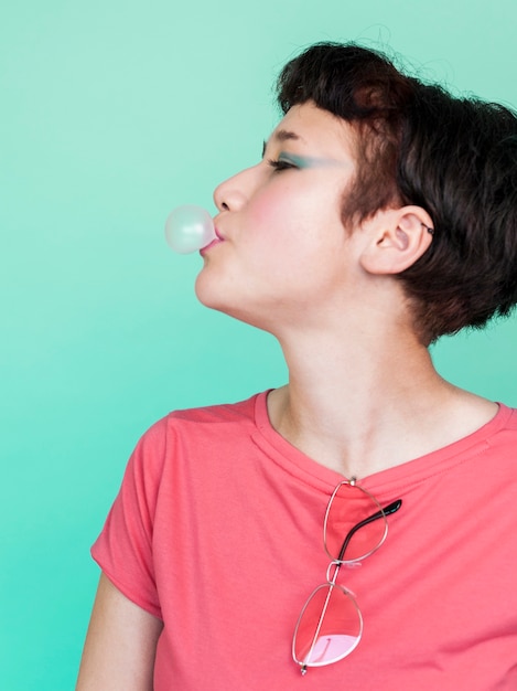 Free photo side view model blowing bubble gum