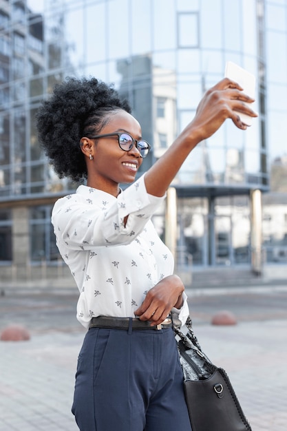 Foto gratuita donna moderna di vista laterale che prende un selfie