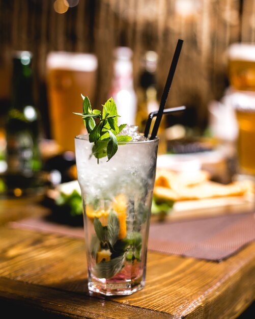 Side view mojito with mint and lemon slices on the table