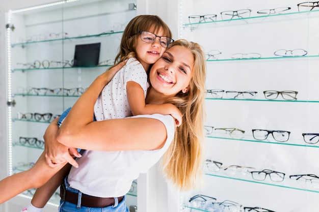 Free photo side view of mom and daughter in shop