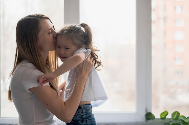 Mamma di vista laterale che abbraccia ragazza