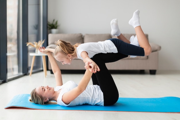 Side view of mother and child working out at home