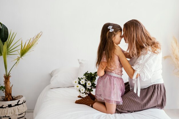 Side view of mother and daughter with bouquet of spring flowers