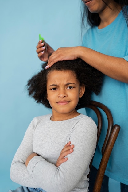 Free photo side view mother helping kid with lice