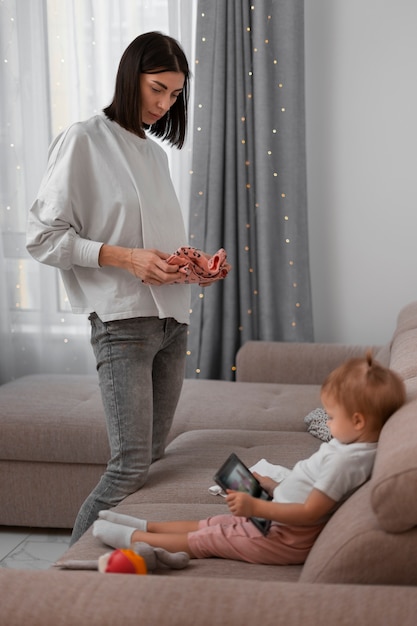 Free photo side view mother holding clothes