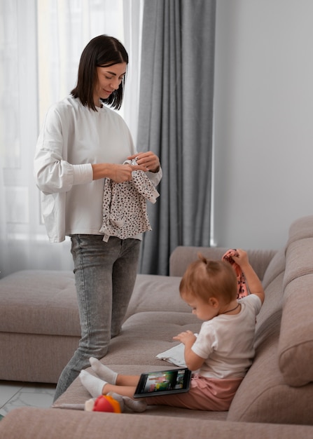 Free photo side view mother holding clothes