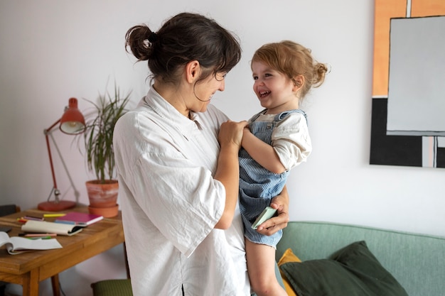 Side view mother holding smiley girl