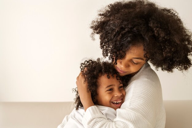 Side view mother hugging kid