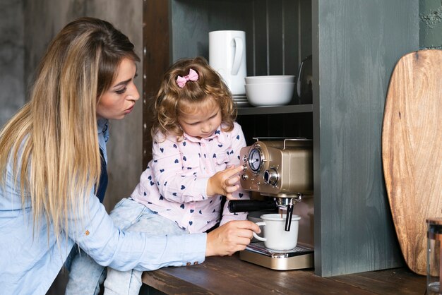 Side view mother making coffee with daughter