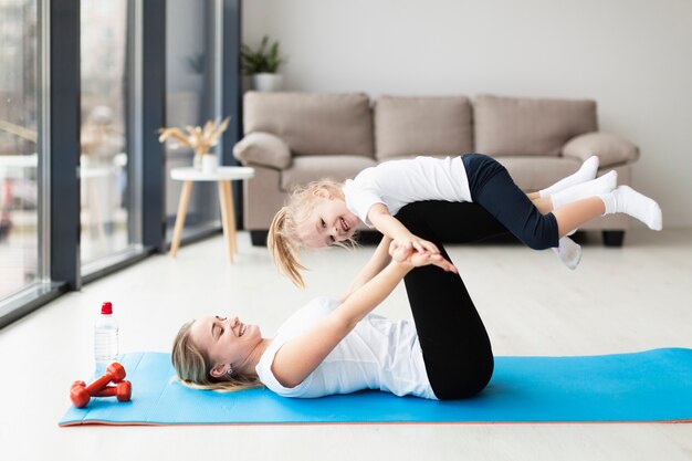 Side view of mother and smiley child working out at home