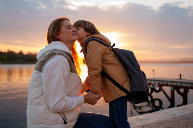 Foto gratuita vista laterale madre e figlio che vanno in giro su un molo