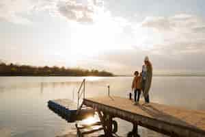 Free photo side view mother and son hanging out on a jetty