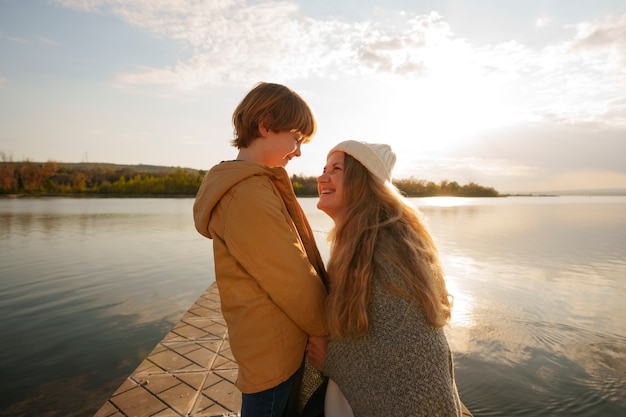 Side view mother and son hanging out on a jetty