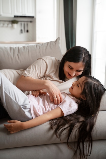 Free photo side view mother tickling girl