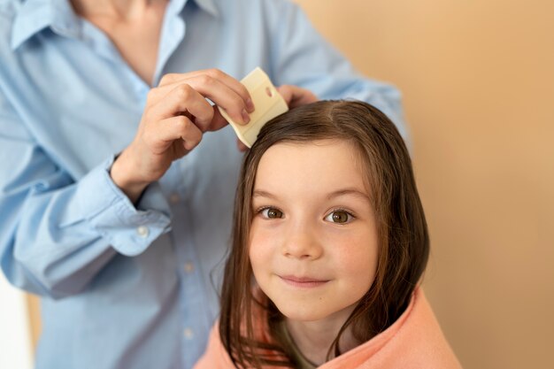 Side view mother using hair comb