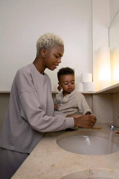 Side view mother washing kid's hands