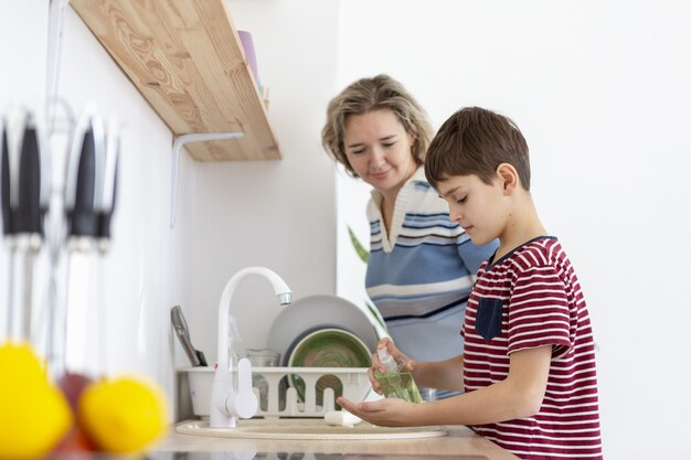 Side view of mother watching son wash his hands
