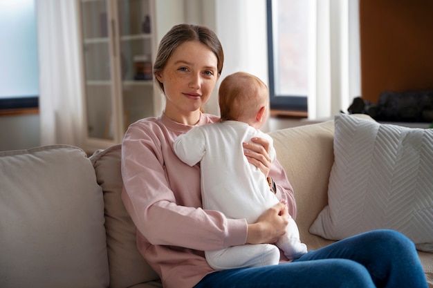 Free photo side view mother with cute newborn