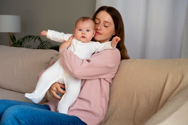 Free photo side view mother with cute newborn