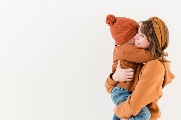 Side view mother with son in her arms