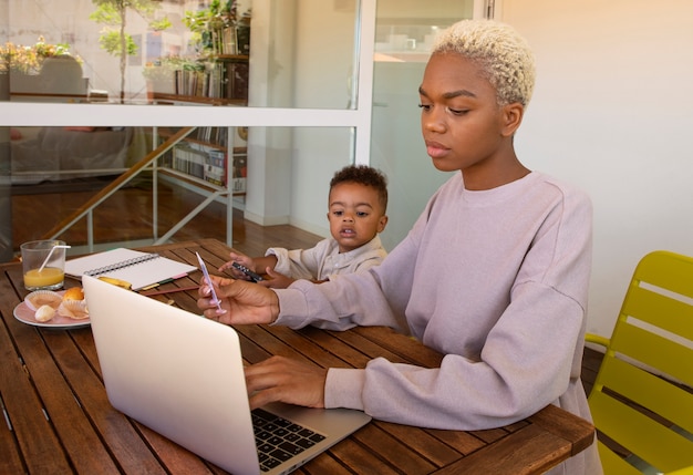 Free photo side view mother working from home