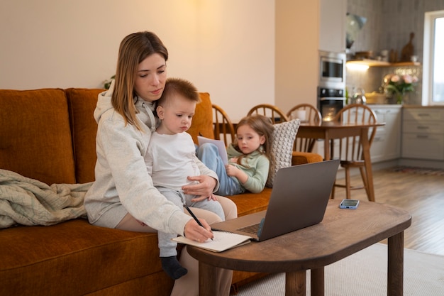 Free photo side view mother working remotely