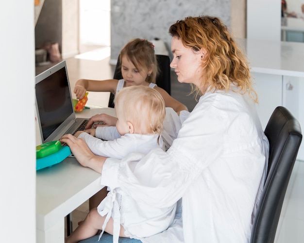 Foto gratuita vista laterale madre che lavora con il bambino