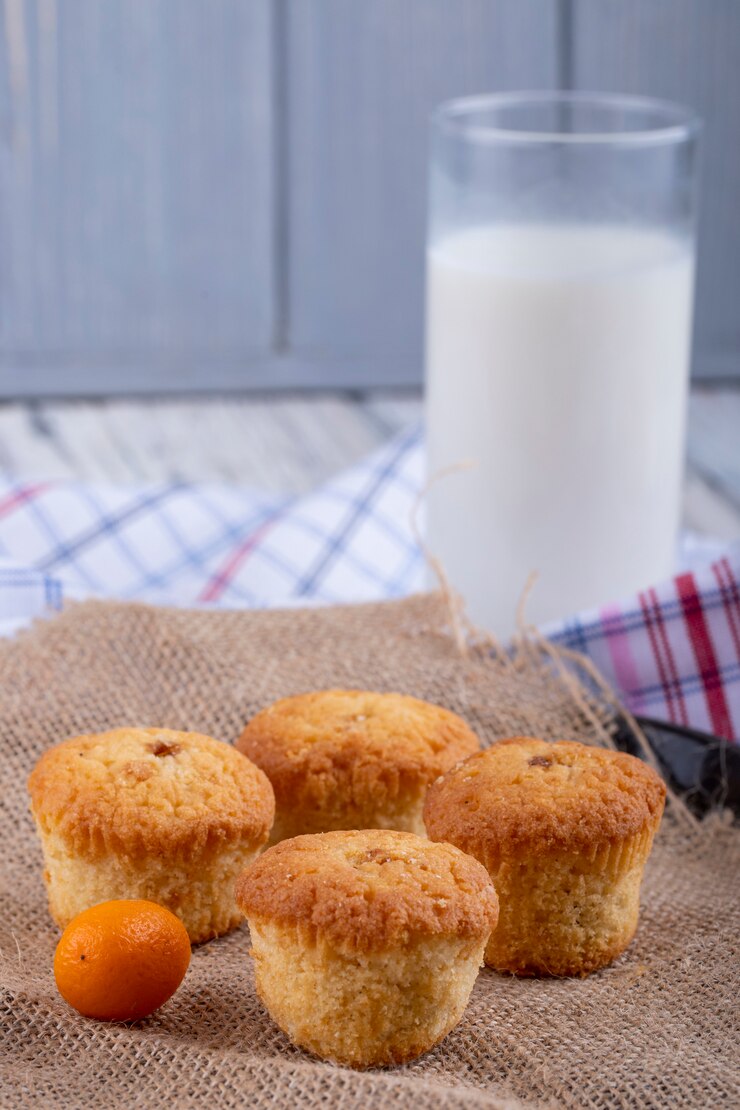 Free Photo side view of muffins and a glass of milk on the table