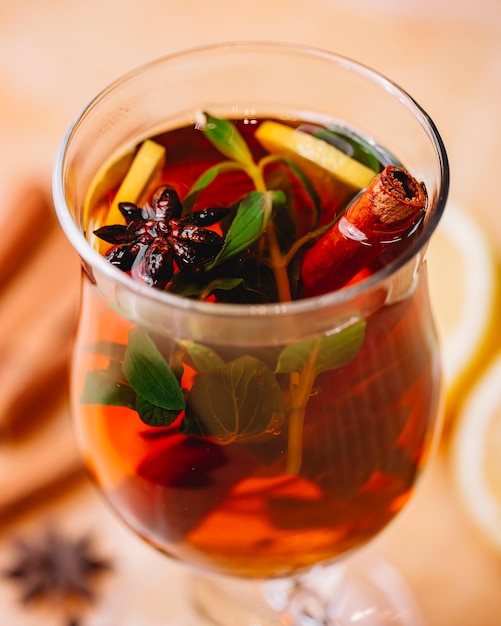 Side view of mulled wine with cinnamon anise and orange in a glass
