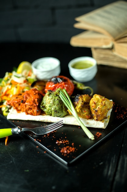 Side view multi colored meatballs with tomato and sauces and green onions