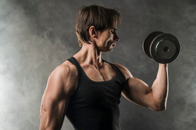 Side view of muscly man holding weight