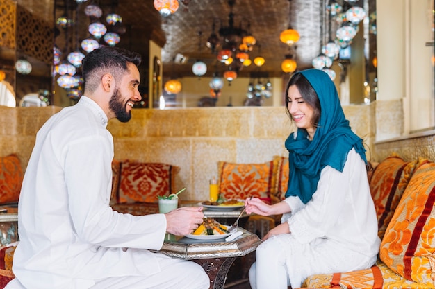 アラブのレストランでイスラム教徒のカップルの側面図