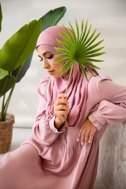 Free photo side view muslim woman holding leaf