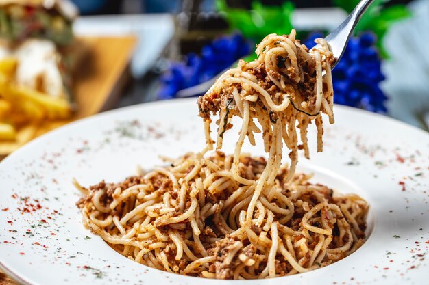 Side view navy-style pasta with ground meat onion and macaroni on a plate