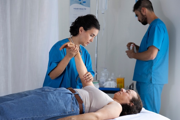 Free photo side view nurse helping patient