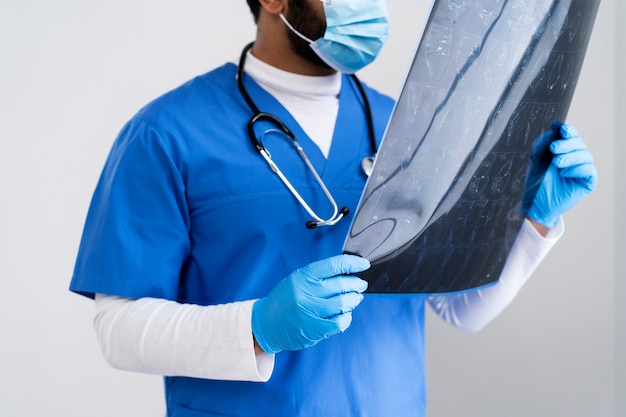 Free photo side view nurse looking at radiography