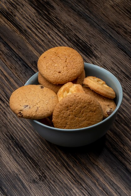 Side view of oatmeal cookies in a bowl on wooden