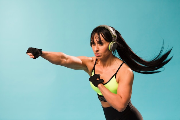 Бесплатное фото Взгляд со стороны атлетической женщины в пробивать снаряжения спортзала