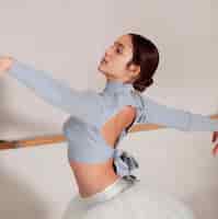 Бесплатное фото Вид сбоку на репетицию балерины в юбке-пачке