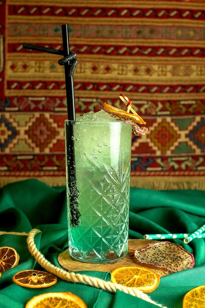 無料写真 緑の乾燥オレンジスライスで飾られた緑のカクテル予測に基づくラム酒とガラスのミントの側面図