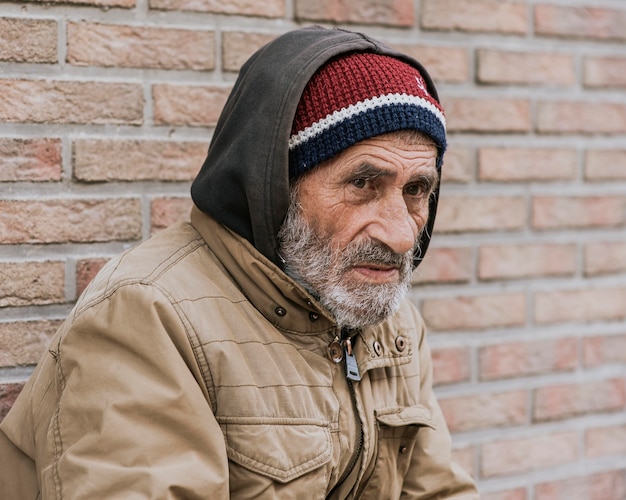 Бесплатное фото Бездомный мужчина снаружи, вид сбоку