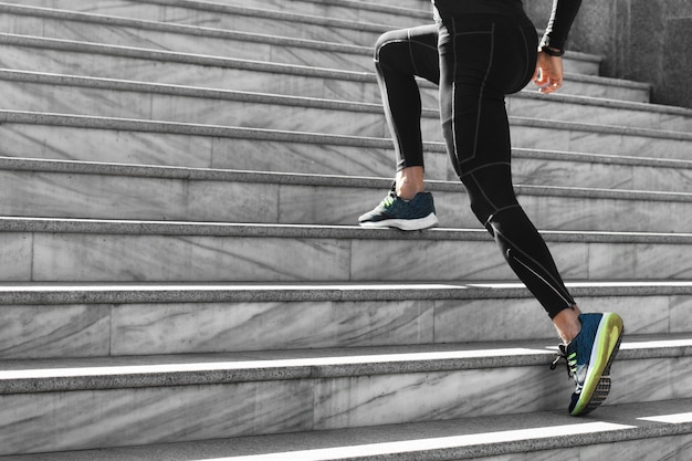 Бесплатное фото Вид сбоку человека в спортивной одежде, тренирующегося на лестнице на открытом воздухе