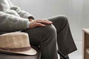 Бесплатное фото Вид сбоку человека в шляпе в доме престарелых