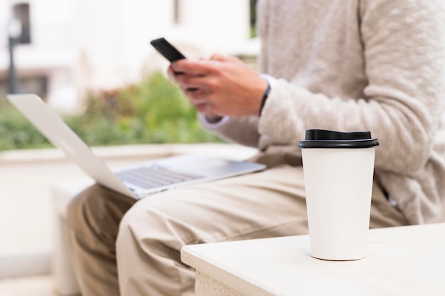 무료 사진 커피 한 잔을하면서 노트북에서 일하는 사람의 모습