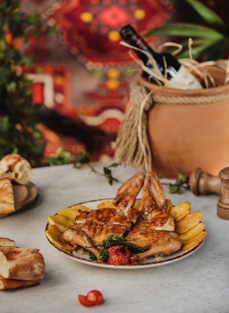 Бесплатное фото Вид сбоку жареной курицы запеченный картофель и овощи на гриле на тарелку на столе