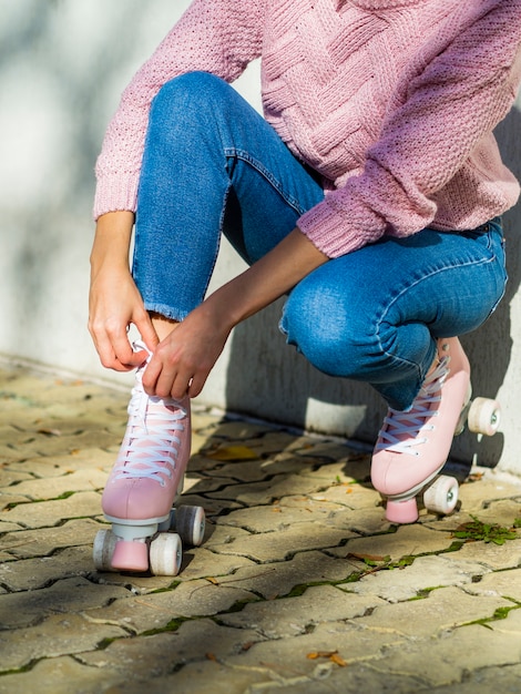 Бесплатное фото Вид сбоку женщины в джинсах с роликовыми коньками