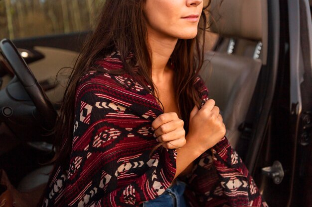 車に座っている間毛布をかぶる女の側面図 無料の写真