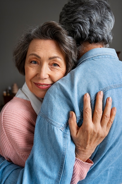 Free photo side view old couple hugging