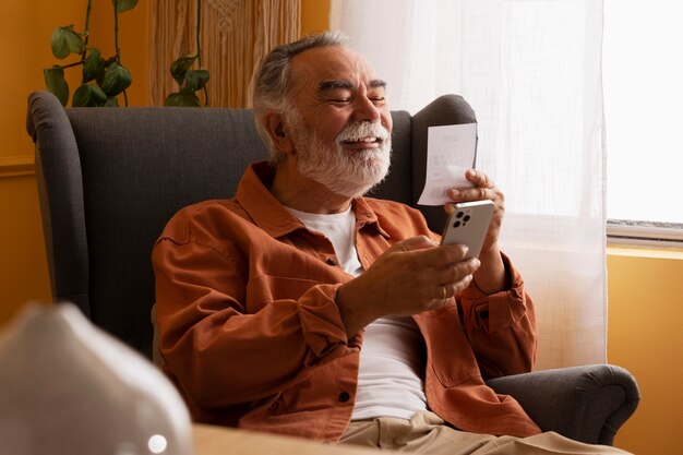 Side view old man holding smartphone