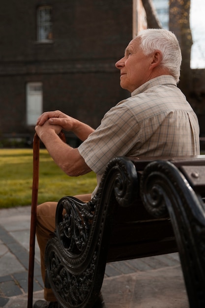 Side view old man sitting on bench